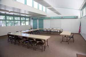 Classroom with u-shaped table and an American flag in the corner.