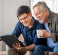 Young man showing older man something on an electronic device