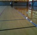 Person applying a first coat to resurface the gym floor.