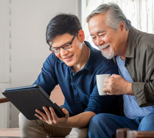 Young man showing older man something on an electronic device
