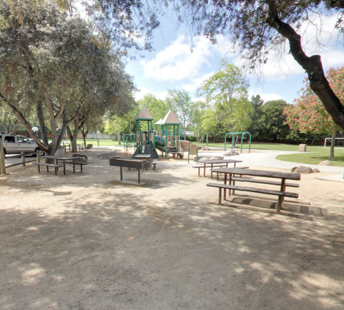 Sideview of Grant Park that includes a picnic table and child's playground