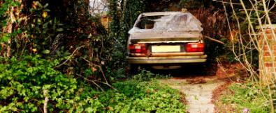 Abandoned and inoperable vehicle stored in yard