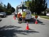 two people operating a Vac-Con Truck on the street