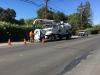 a person using a Vac-Con Truck to work on the side of a road